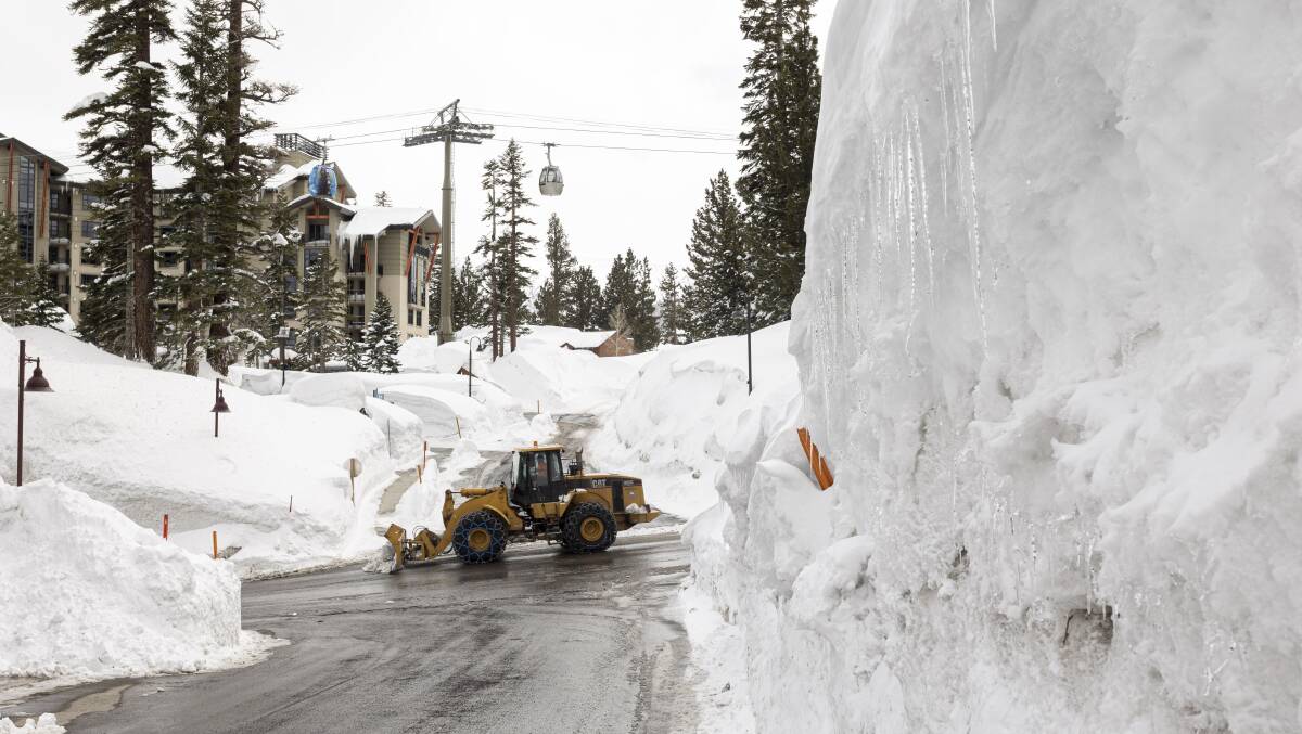 Mammoth Mountain: One of a small army of articulated excavators working to clear streets and homes. Picture: Scott Hannaford