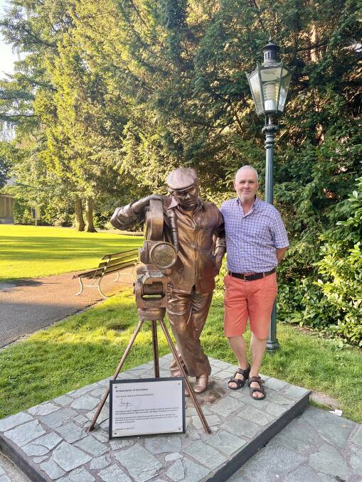Bollywood tour guide Erwin Fassler next to the statue of Indian film director Yash Chopra in Interlaken. Picture: Akash Arora