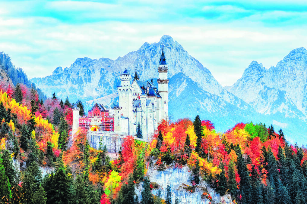 Neuschwanstein medieval castle in Germany, Bavaria land. Beautiful autumn scenery of Neuschwanstein ancient castle circled by colorful tree, amazing seasonal fall scene. Famous and popular landmark.