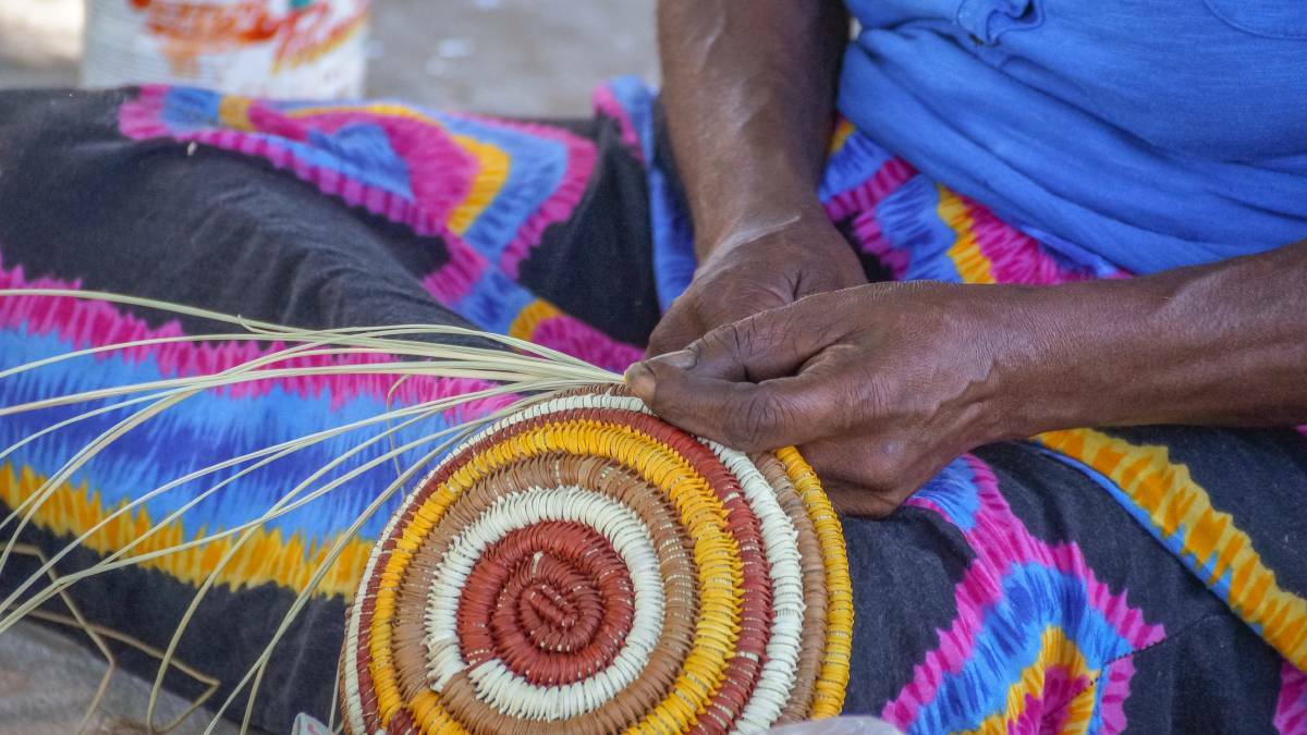 Weaving pandanus leaves into items to sell at Injalak Arts.