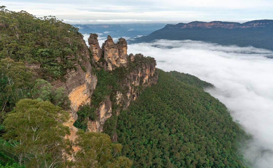 The fog rolls in around the Three Sisters, as seen from Echo Point.